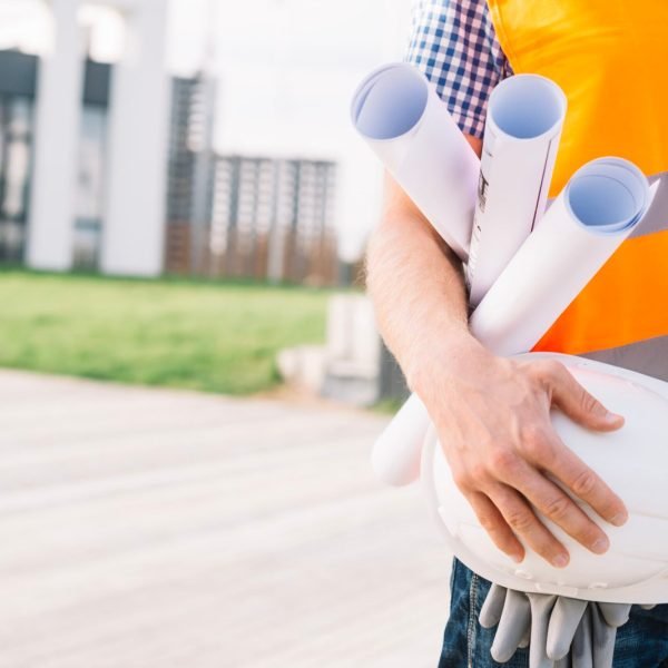 crop-man-with-blueprints-helmet-scaled.jpg