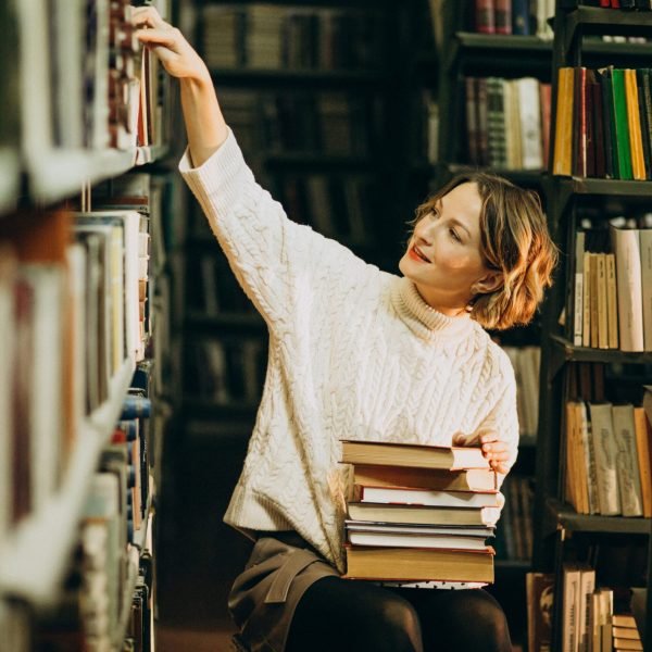 Young woman studying at the library Revalidación de materias